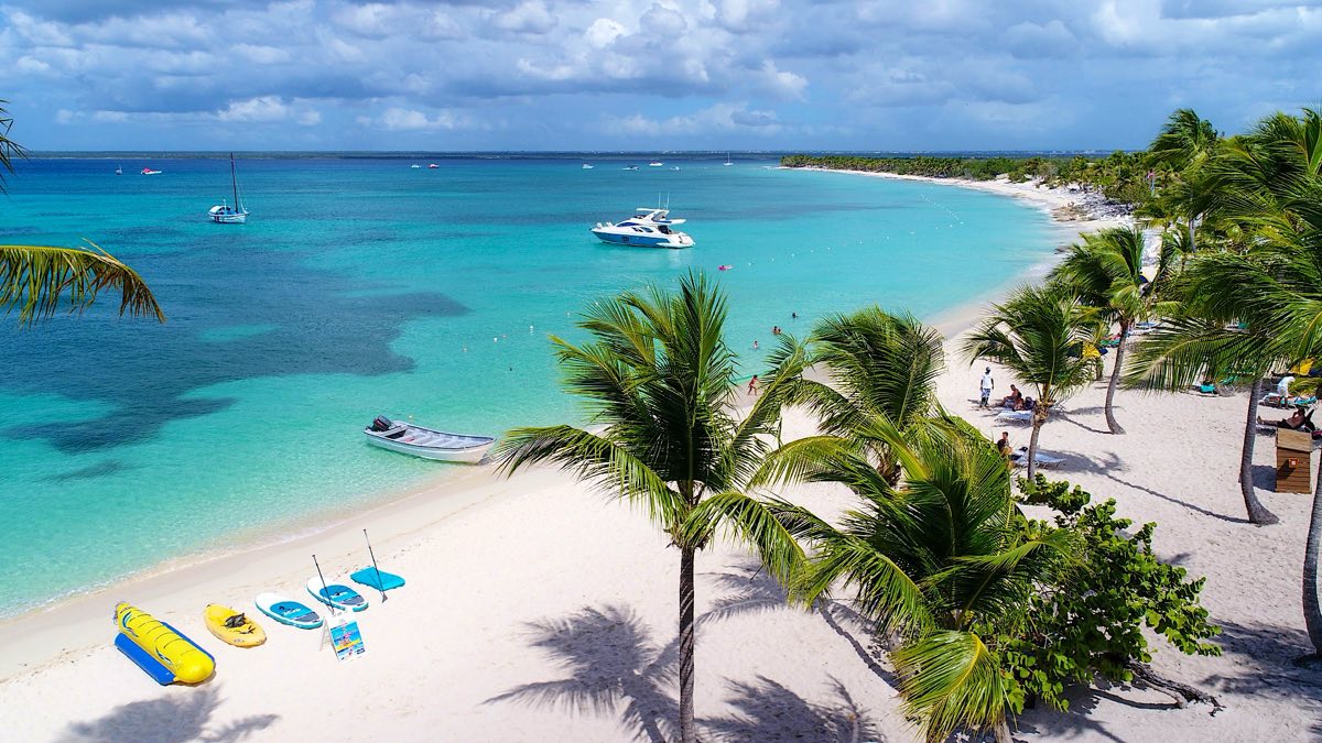 White-sand beach with boats in crystal-clear water